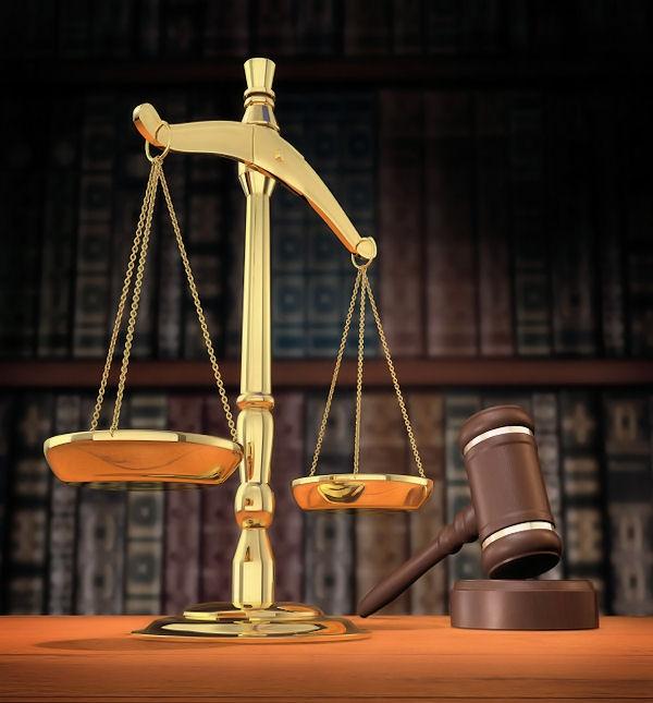 Scales of justice and gavel on desk with dark background that allows for copyspace.